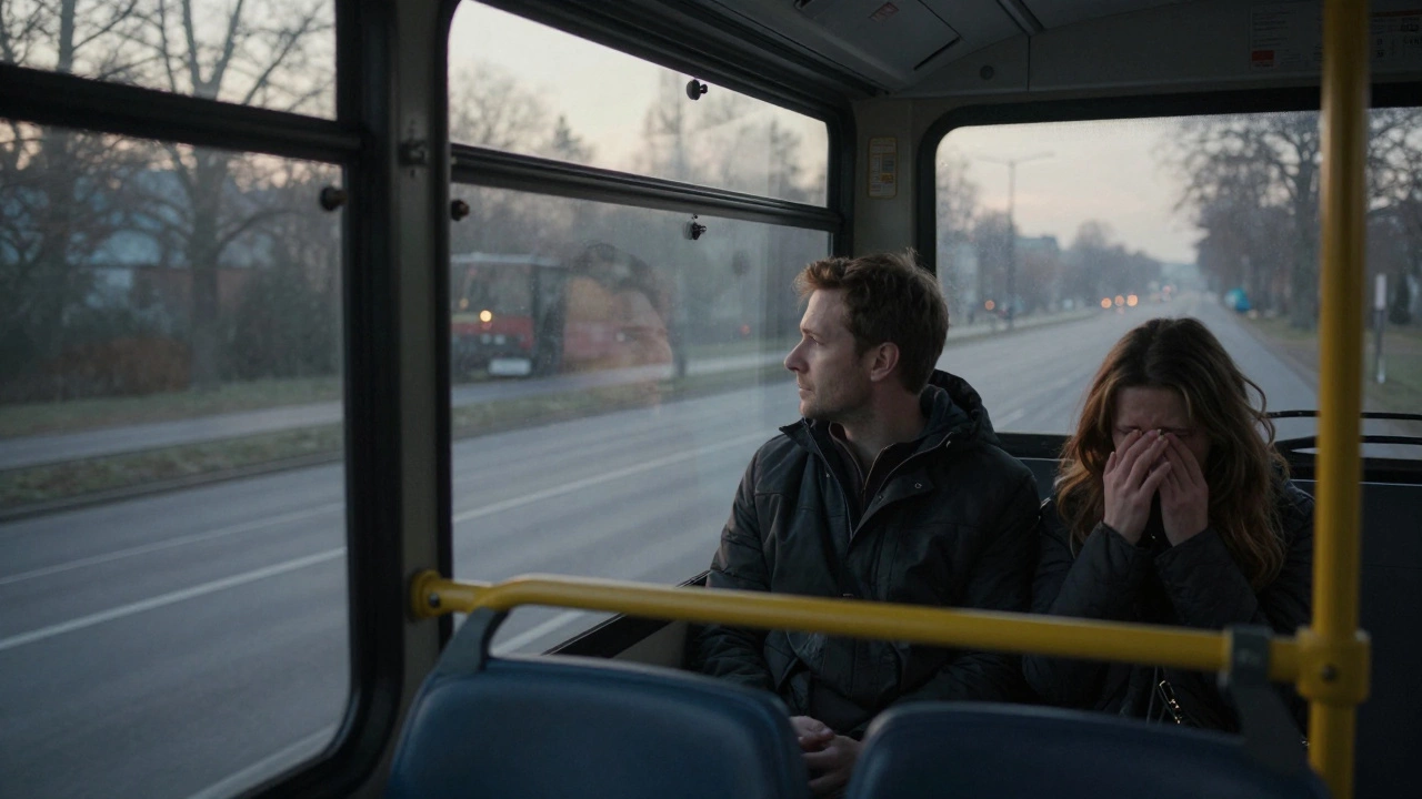 Two passengers sit in quiet solidarity on a dawn bus, one quietly crying.